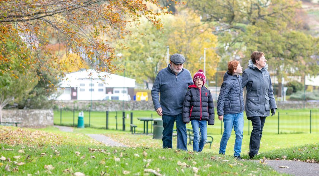 Family of four walking through a park